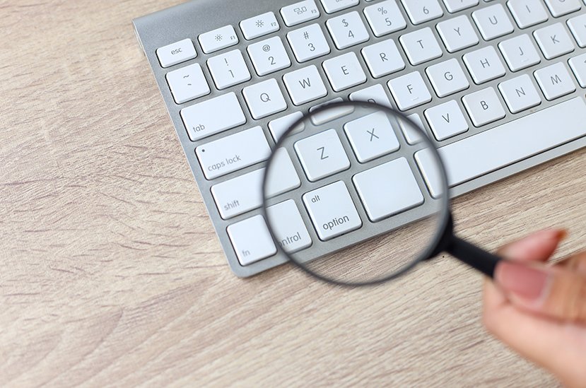 document review, keyboard with magnifying glass over it
