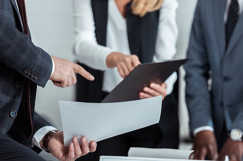 business people holding papers, document review