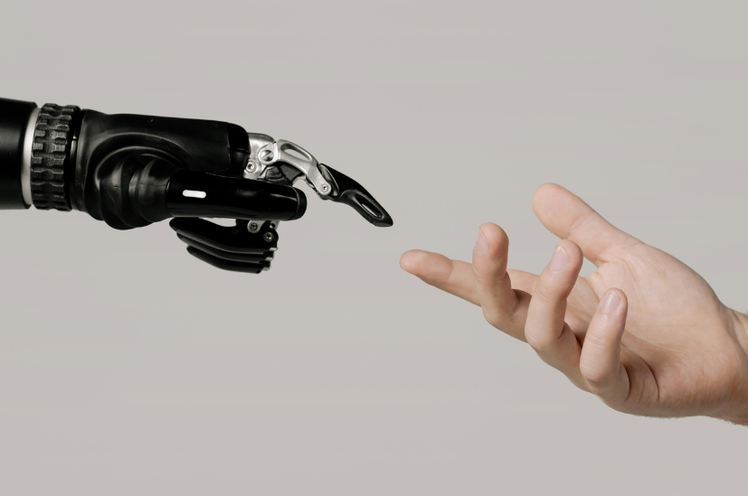 Human hand reaching toward a robotic hand, symbolizing collaboration and connection between humans and artificial intelligence AI.