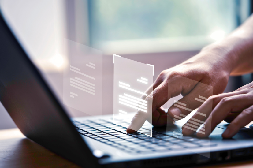 Hands typing on laptop with floating digital documents, representing GenAI and review tech at Tanenholz & Marr.